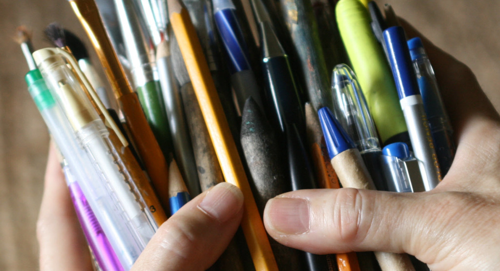 Dorene's hands filled with pencils, pens, paint brushes and markers - the tools I use in finding my creative self